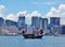 A Chinese junk ship in front of the Hong Kong skyline