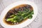 Chinese kale on oyster sauce, Stir fried shiitake mushroom with chinese kale cooked vegetable on white plate on the dining table