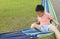 Chinese kid on hammock, holding edge to stable