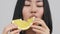 Chinese Lady Eating Slice Of Juicy Orange Over White Background