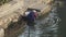 Chinese man wash cloths in river.