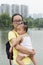 Chinese mom holding daughter in arms in city