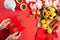 Chinese new year festival decorations. Woman hand holding pow or red packet, orange and gold ingots on a red background. Chinese