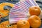 Chinese New year, tangerines and a fan lying on the silk fabric with an embroidered dragon