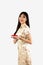 Chinese new year woman concept, asian woman wearing gold Cheongsam dress and holding plate of teas
