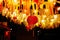 Chinese paper red lanterns hang with garlands of ribbons and lamps at night in the yard