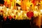 Chinese paper red lanterns hang with garlands of ribbons and lamps at night in the yard