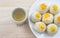 Chinese Pastry Mung Bean or Mooncake with Egg Yolk on dish wooden table and green tea