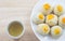 Chinese Pastry Mung Bean or Mooncake with Egg Yolk on dish wooden table and green tea