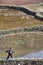 Chinese peasant woman is on path along flooded rice fields.