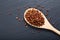 Chinese pepper, Sichuan pepper in wooden spoon on black slate stone plate