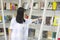 Chinese Portrait of young beautiful woman reaching for a library book In Bookstore