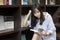 Chinese Portrait of young beautiful woman reads Book In Bookstore