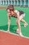 Chinese runner at starting position on racetrack