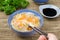 Chinese soup with noodles and vegetables and hand with chopstick