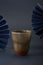 Chinese style grey blue background and blue folding fan and traditional rough ceramic cup