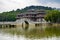 Chinese style pedestrian stone arch bridge over lake in park