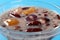 Chinese syrup of red bean and sago with shredded coconut on blue background close up