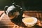 Chinese tea ceremony. Teapot and a cup of green puer tea on wooden tabl with small amount of vapour. Asian traditional culture.