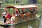 Chinese Tourists take an Ancient Boat on a River or Small Lake