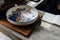 Chinese traditional decorative ceramic plate on wooden block with open notebook on kitchen counter