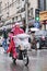 Chinese woman dressed in rainwear on an e-bike. Shanghai, China