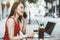 Chinese woman freelancer in a cafe talking on the phone