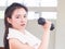 Chinese woman looking strong lifting dumbbell