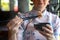 Chinese woman in traditional cheongsam or qipao dress using chopsticks in Chinese restaurant. Fashion woman eating a