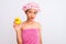 Chinese woman wearing shower towel and cap holding duck toy over isolated white background with a confident expression on smart