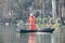 Chinese worker cleaning leaves from the lake by hand, day, boat, standing