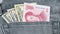 Chinese yuan and US dollar banknote in the grey jean pocket
