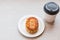 A Chiness moon cake with a hot disposable coffee cup