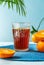 Chinotto refreshing citrus drink with fruits, palm branch on bleu background. Vertical banner with copy space