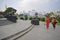 Chinthe Statues in Yangon Myanmar with beautiful women in Red in front & temple & colonial buildings in the background