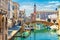 Chioggia cityscape with narrow water canal with moored multicolored boats, old buildings