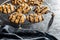 Chip cookies with peanuts and chocolate strips on black table