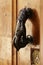 Chipped doorknocker with hand shape on wooden door