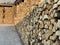 Chipped dry firewood is ready for winter. Background of logs, birch, pine and oak. A wall of chopped firewood, ready for burning