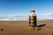 Chirihama Beach Driveway, Noto, Japan, 10/11/19. Bottle of hot Tully`s Coffee Barista`s Black  buried in the sand on the beach.