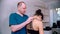 Chiropractic treatment - the doctor inspecting the young woman before the session - bending the neck down