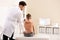 Chiropractor examining child with back pain