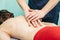 Chiropractor making treatment procedures. Young woman relaxing on massaging table, masseur working with her back. Beauty, health,
