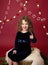 Chirstmas Child on tree stump and pine tree branches, Red Holiday