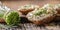 Chive cream cheese spread on a bread slices next to bunch of freshly cut chives on a rustic wood and chopping board