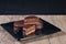 Chocolate alfajor on black plate on a wooden table and dark background