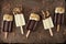 Chocolate and almond dipped white and dark popsicles on rustic metal