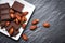 Chocolate almonds nut on white plate on the dark background - chunks candy sweet dessert and snack