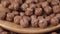 Chocolate balls cereal flakes close-up. Filling a wooden spoon with a drop in slow motion.