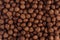 Chocolate balls corn flakes closeup background. Cereals texture.